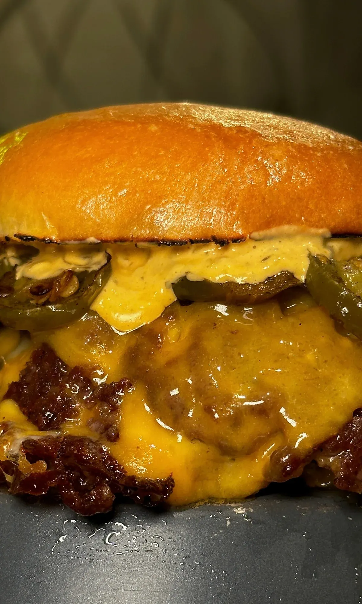Hamburguesa doble con jalapeños, cheddar fundido y salsa, muy de cerca